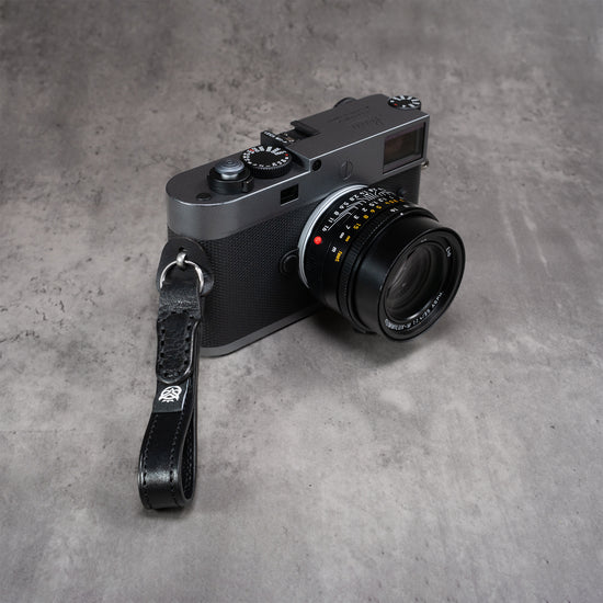 Leather Thumb Strap - Stealth hanging from a Leica M lug