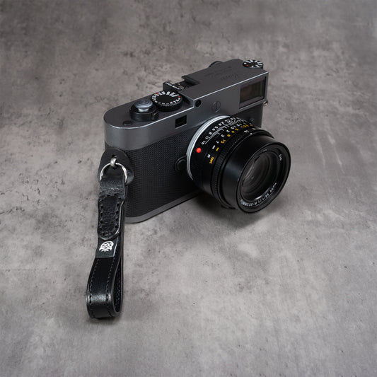Leather Thumb Strap - Stealth hanging from a Leica M lug