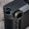 Owlkrown M-EyeKup in Black Patina threaded onto a Leica M rangefinder eyepiece, angled top view