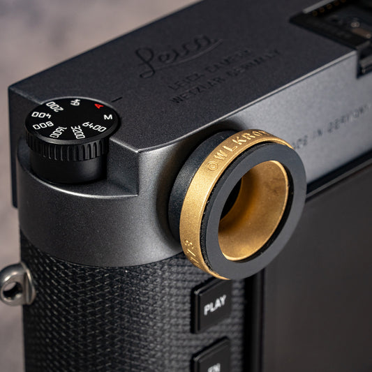Owlkrown M-EyeKup in Solid Brass threaded onto a Leica M rangefinder eyepiece, angled top view
