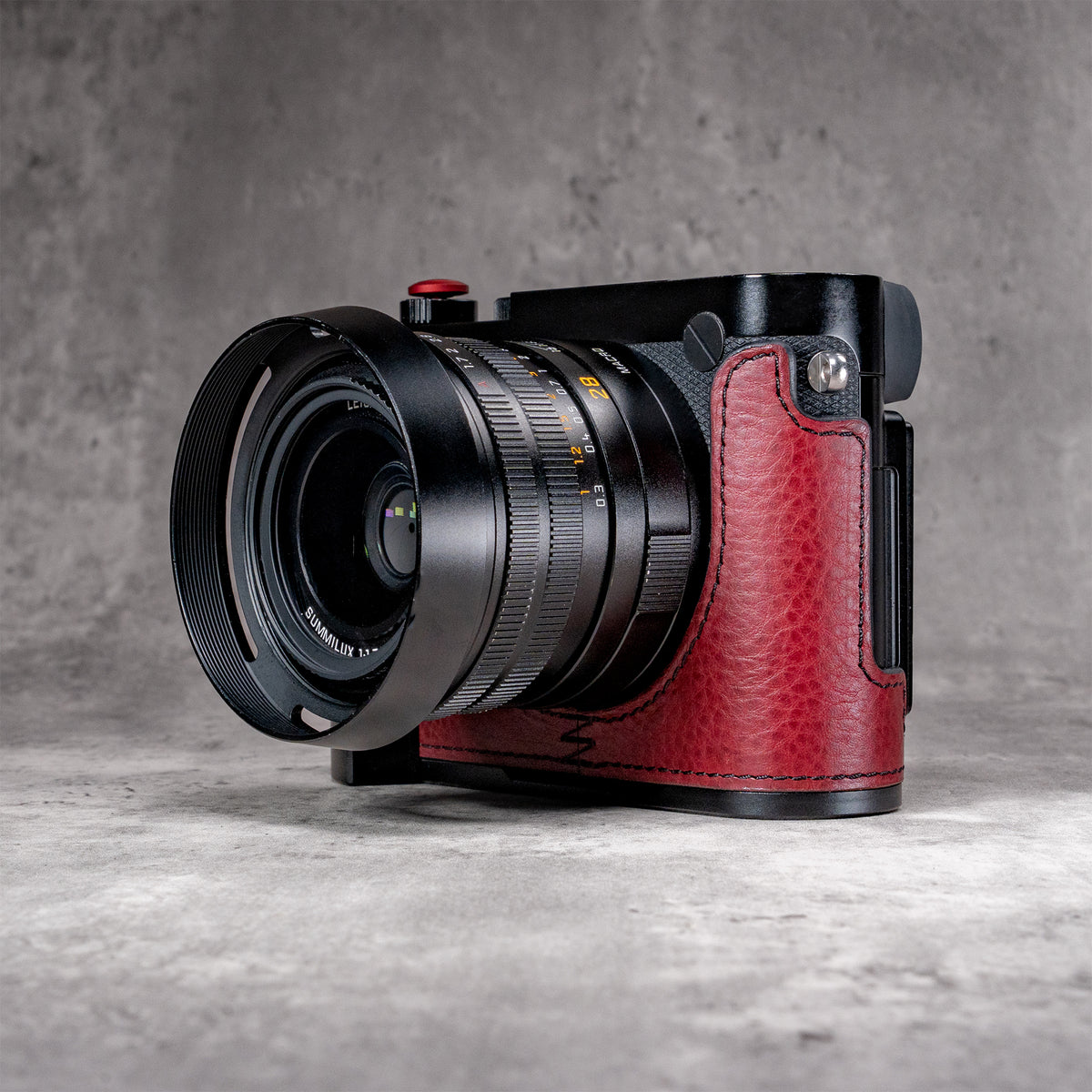 OxBlood FlexCase on a Leica Q, angled front with the lens hood fitted