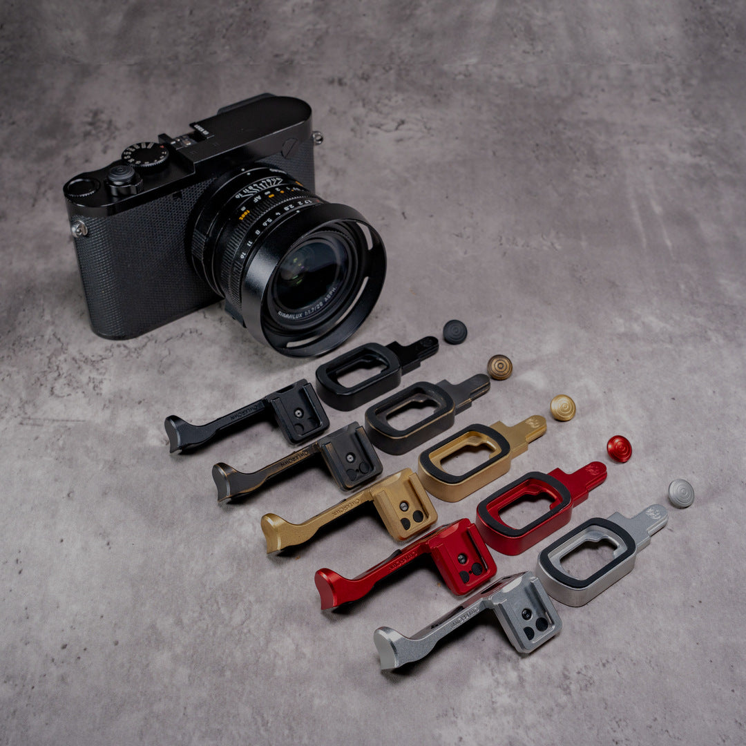 The Leica Q with five ProKits laid out beside it in Black Chrome, Black Patina, Solid Brass, OxBlood and Silver Chrome