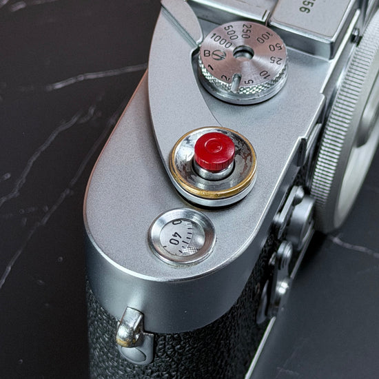 Red Cerakote Shutter Topper fitted to the shutter release of a chrome Leica M3