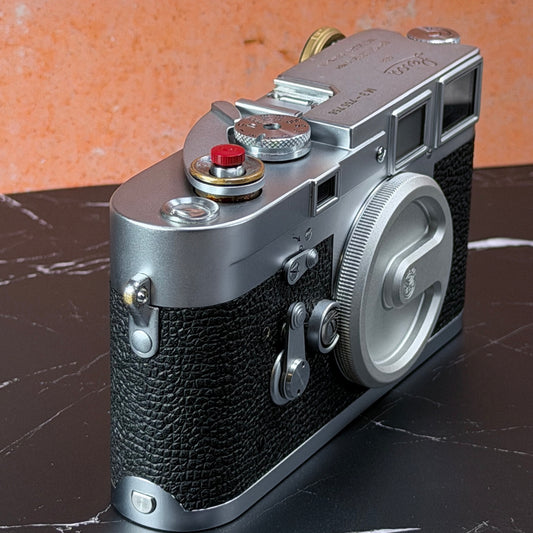 Chrome Leica M3 on black marble with the Red Cerakote Shutter Topper fitted