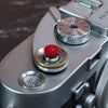 Close view of the Red Cerakote Shutter Topper seated in a Leica M3 shutter button